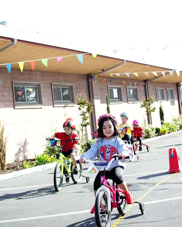 kid on bike smiling at camera